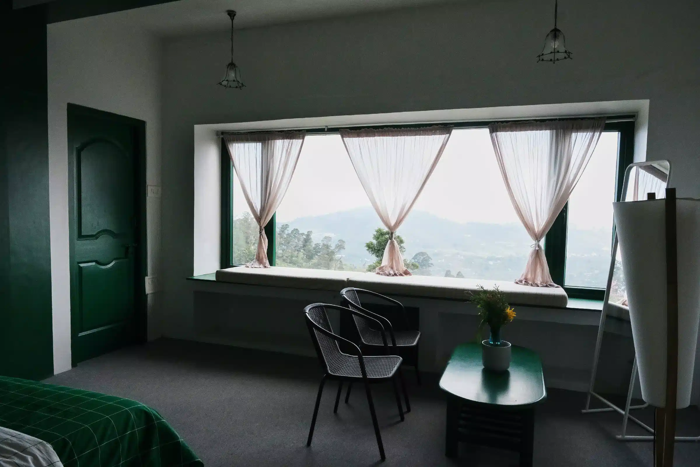 Resort room interior in Kodaikanal with large window and valley view