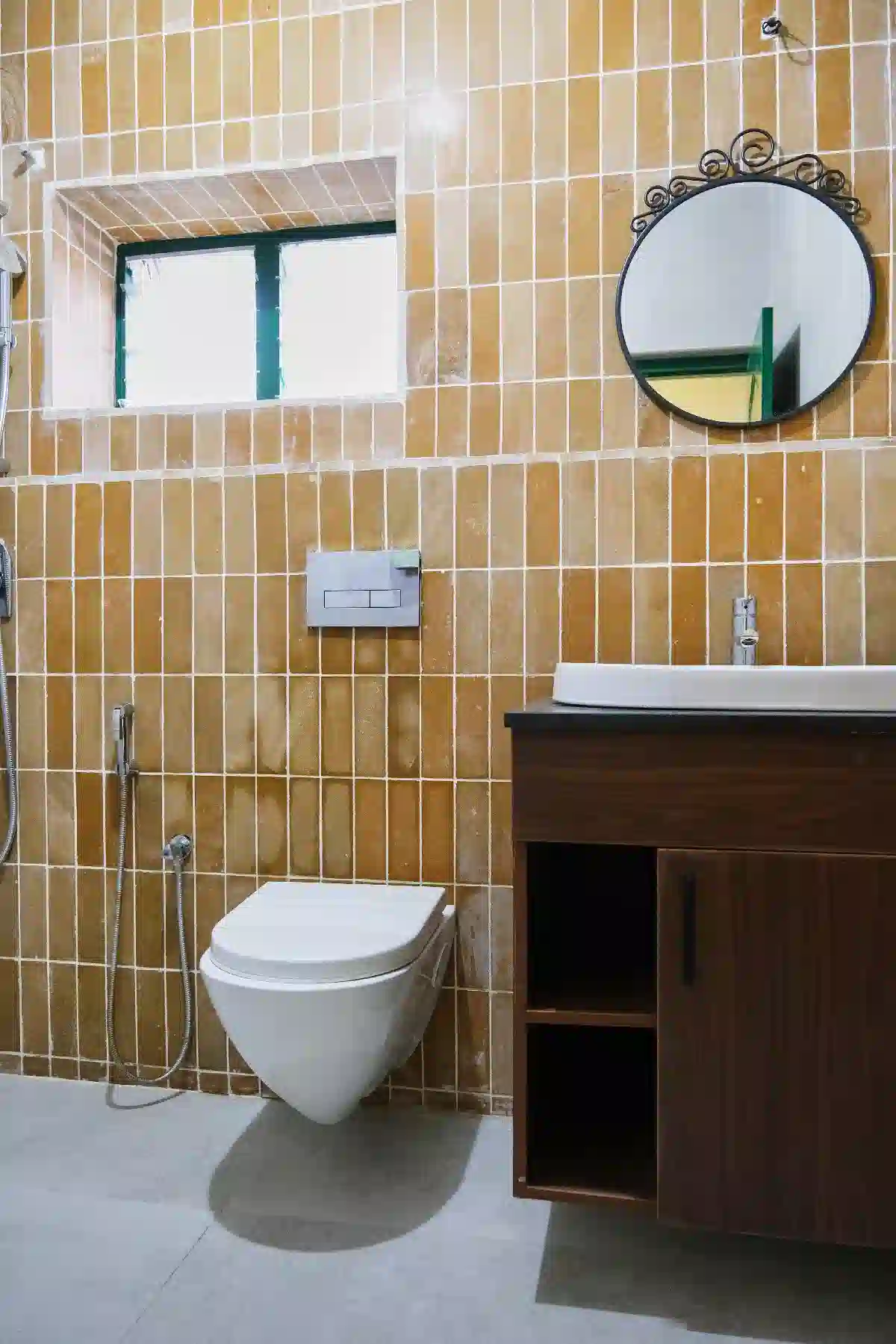 Modern bathroom at Cardamom Pods for couples featuring mustard yellow tiles, wood vanity and sleek white wall fixtures.